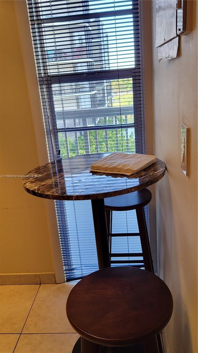 tiled dining room featuring baseboards