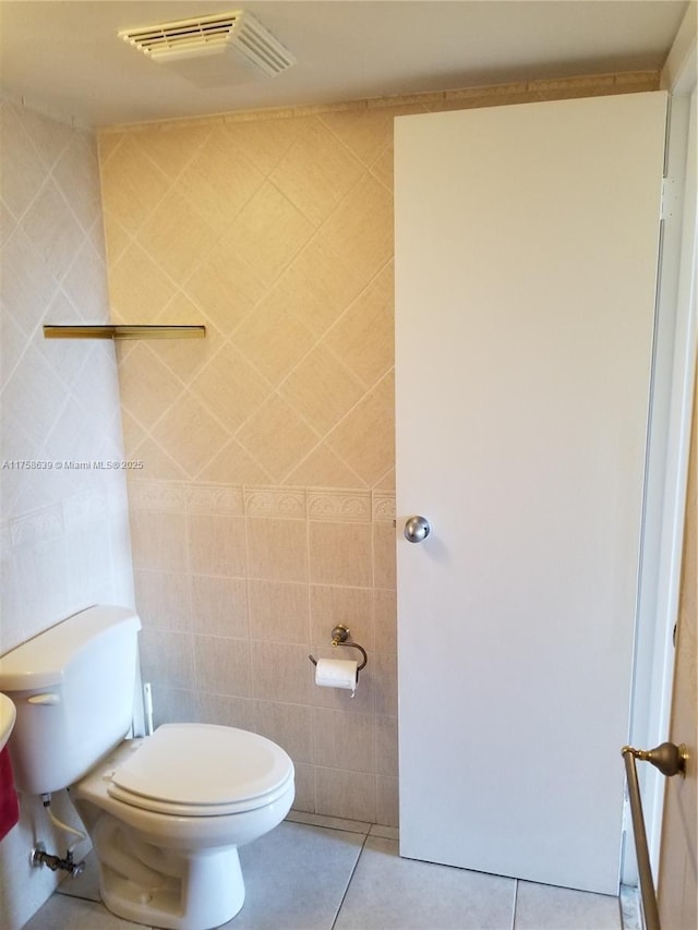 bathroom featuring visible vents, tile walls, toilet, and tile patterned floors