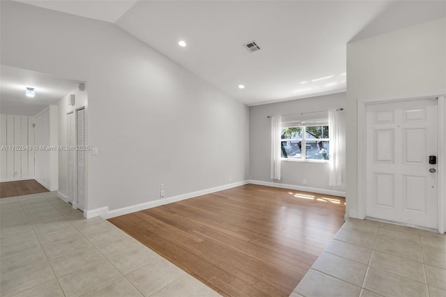 empty room featuring visible vents, wood finished floors, recessed lighting, baseboards, and lofted ceiling