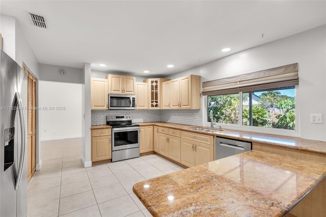 kitchen with visible vents, decorative backsplash, light tile patterned flooring, stainless steel appliances, and a sink