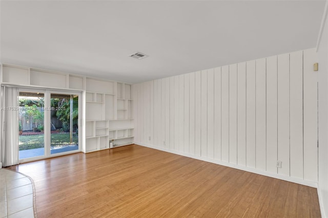 unfurnished room with light wood finished floors and visible vents