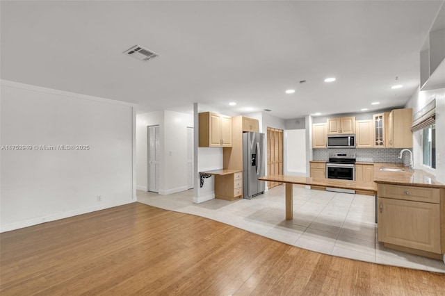 kitchen featuring light brown cabinets, visible vents, and appliances with stainless steel finishes