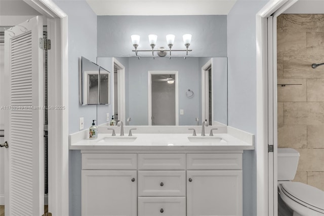 full bathroom with a sink, a closet, toilet, and double vanity