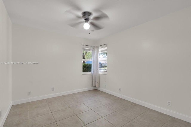 spare room with baseboards, light tile patterned flooring, and a ceiling fan