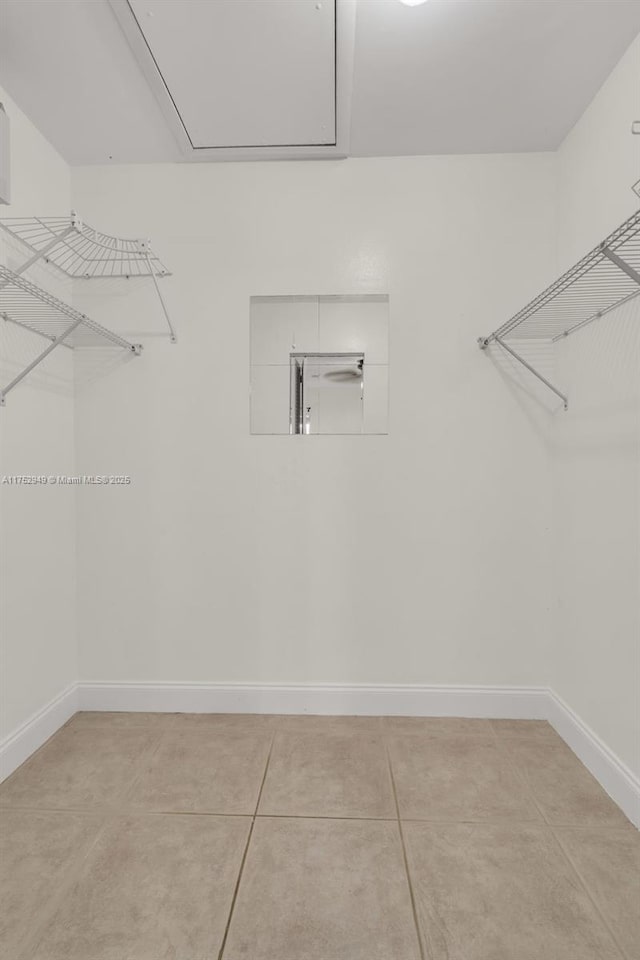 walk in closet with light tile patterned floors