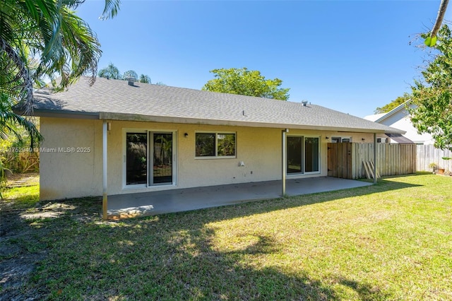 back of house featuring a patio area, a yard, fence, and stucco siding