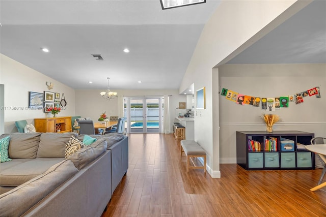 living room with an inviting chandelier, baseboards, wood finished floors, and recessed lighting