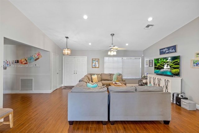 living room with visible vents, vaulted ceiling, and wood finished floors