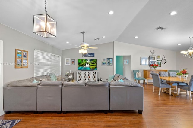 living area featuring lofted ceiling, wood finished floors, visible vents, and recessed lighting