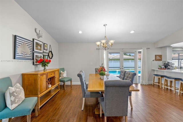 dining area featuring baseboards, recessed lighting, wood finished floors, and a notable chandelier