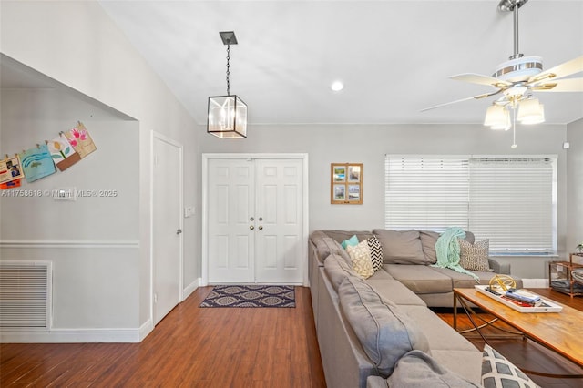 living room with visible vents, ceiling fan, baseboards, and wood finished floors