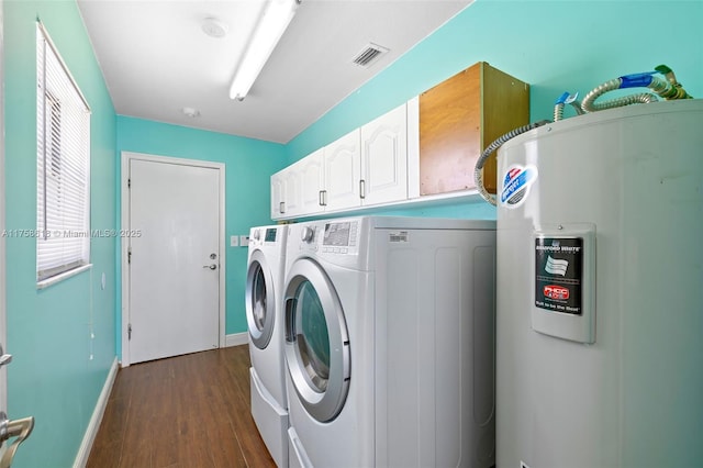 laundry room with cabinet space, visible vents, dark wood-style flooring, washing machine and clothes dryer, and water heater