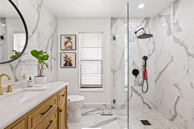 bathroom featuring marble finish floor, vanity, a marble finish shower, and toilet