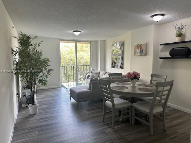 dining room with a textured ceiling, baseboards, and wood finished floors