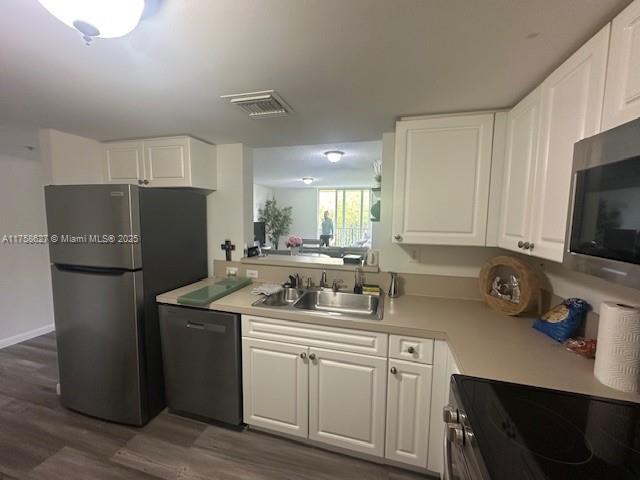 kitchen featuring stainless steel appliances, light countertops, visible vents, and a sink