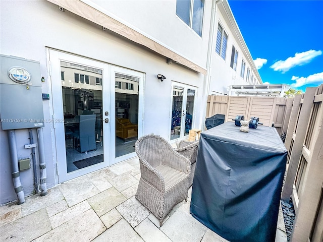 view of patio with french doors, a grill, and fence