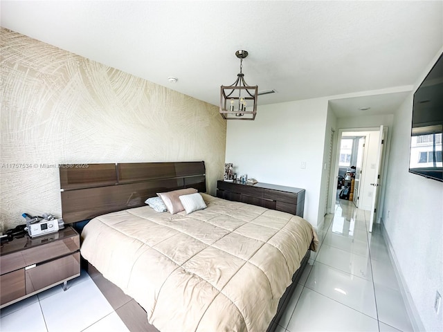 tiled bedroom featuring an inviting chandelier and baseboards