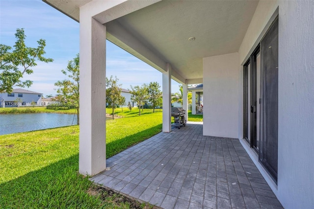 view of patio / terrace with area for grilling and a water view