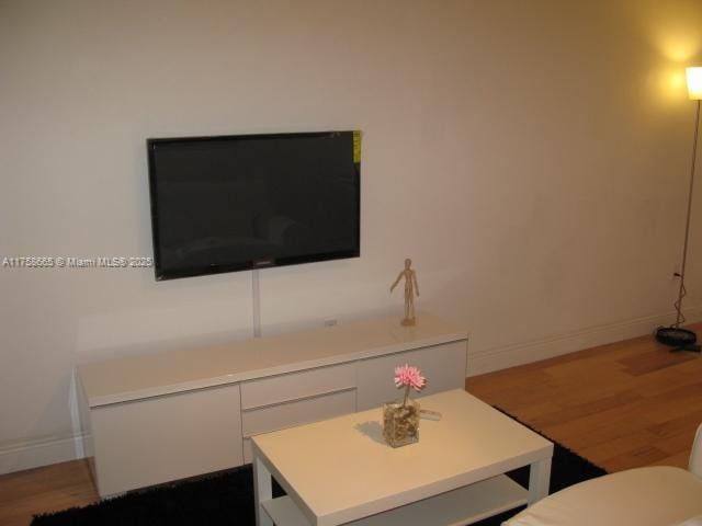 living area featuring baseboards and wood finished floors