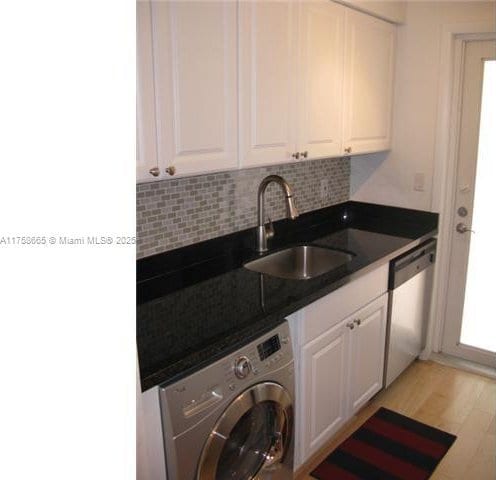 washroom with washer / dryer, light wood-style flooring, laundry area, and a sink