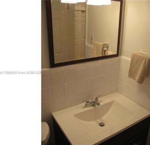 bathroom featuring tile walls, vanity, and toilet