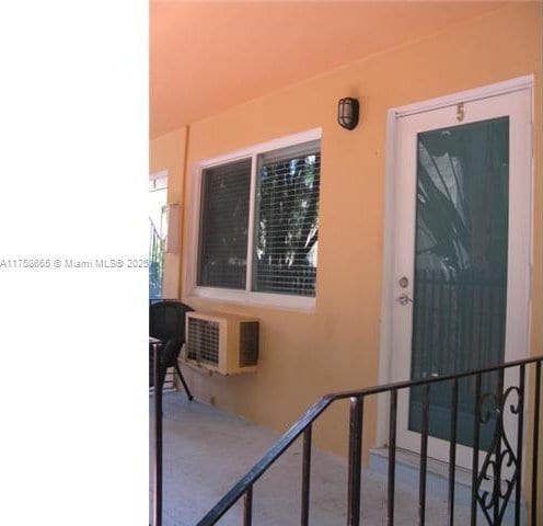 entrance to property with a balcony and stucco siding