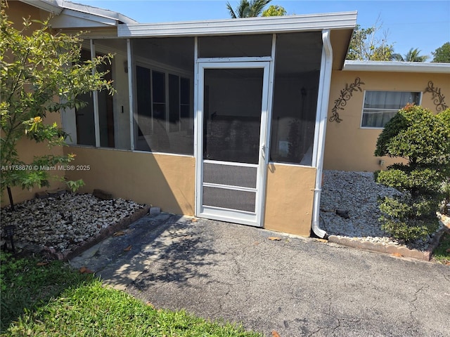 entrance to property featuring stucco siding