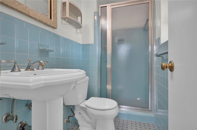 full bathroom featuring a stall shower, tile walls, and toilet