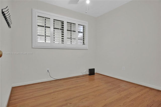 spare room featuring ceiling fan, wood finished floors, and baseboards