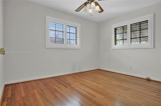 empty room featuring wood finished floors, a wealth of natural light, and baseboards