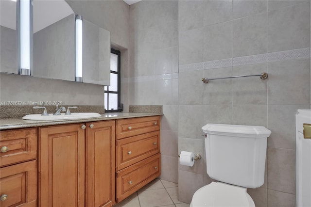 bathroom featuring tile walls, vanity, toilet, and tile patterned floors