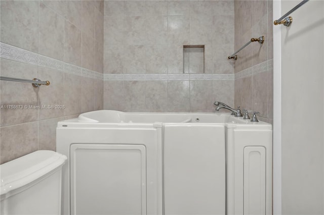 full bathroom with tile walls, toilet, and a bathing tub