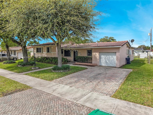 single story home featuring a garage, stucco siding, a tile roof, decorative driveway, and a front yard