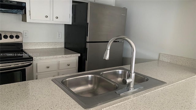 kitchen featuring stainless steel appliances, light countertops, white cabinets, a sink, and extractor fan