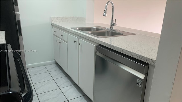 kitchen featuring light tile patterned floors, a sink, light countertops, stainless steel dishwasher, and fridge