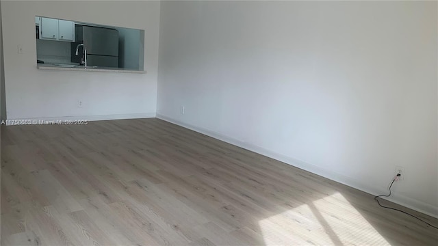 unfurnished room with wood finished floors and baseboards