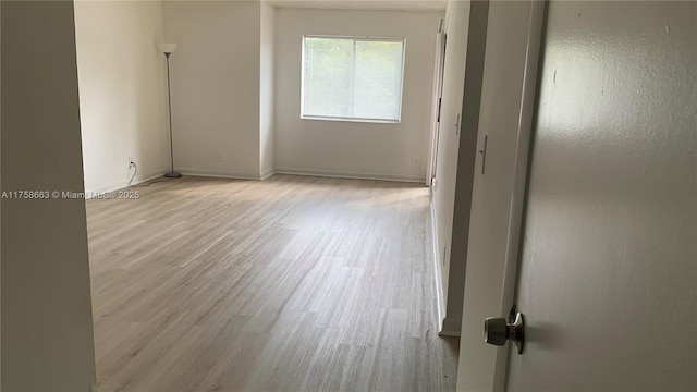 spare room with light wood-style flooring and baseboards