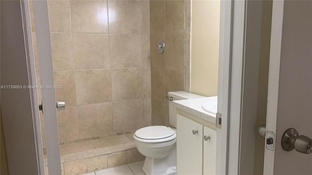 full bath featuring tiled shower, vanity, and toilet