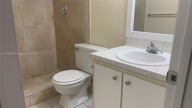 full bathroom with a tile shower, vanity, and toilet