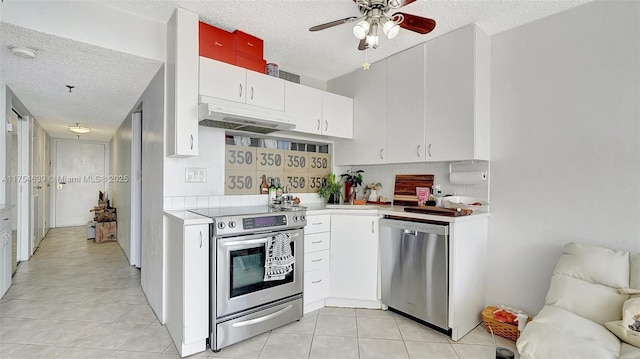 kitchen featuring tasteful backsplash, light countertops, appliances with stainless steel finishes, white cabinets, and under cabinet range hood