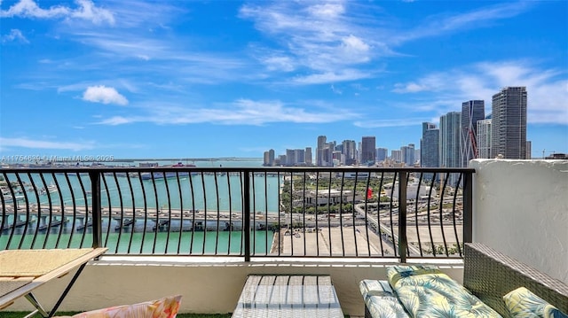 balcony featuring a water view and a city view