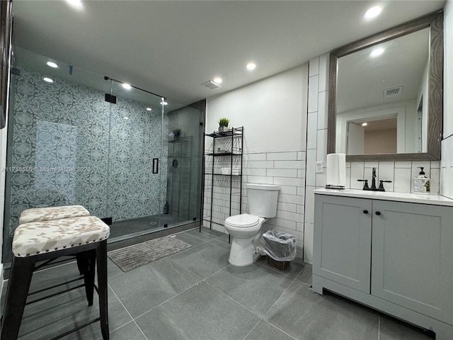 bathroom featuring toilet, recessed lighting, vanity, tile walls, and a shower stall