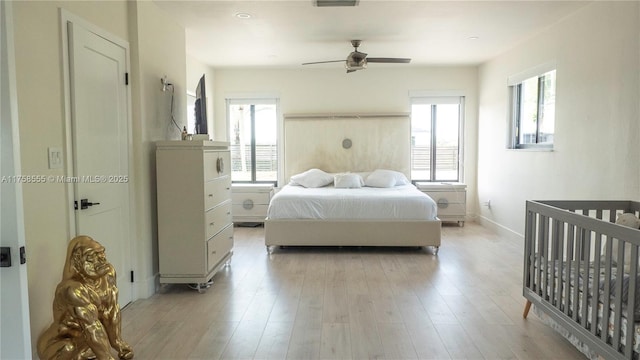 bedroom with baseboards, a ceiling fan, and light wood-style floors