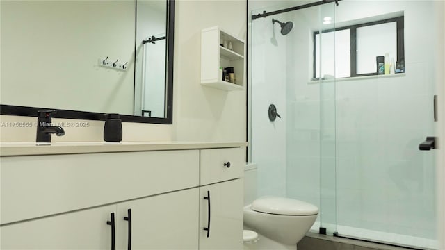 bathroom featuring a shower stall, toilet, and vanity