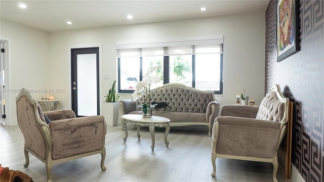 living room with recessed lighting, wallpapered walls, and wood finished floors