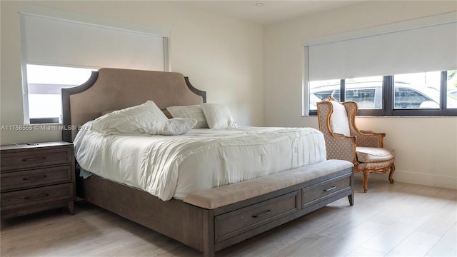 bedroom with light wood-type flooring and baseboards