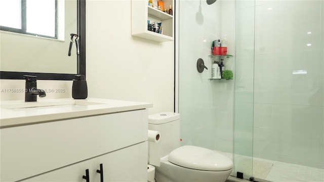 bathroom with toilet, a stall shower, and vanity