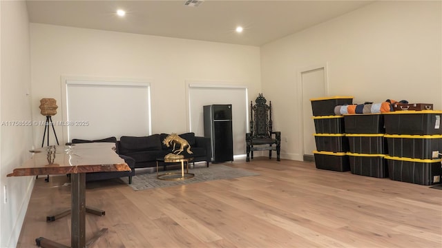 sitting room featuring baseboards, wood finished floors, and recessed lighting