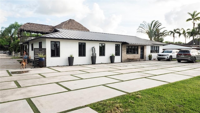 view of front of home with a standing seam roof, metal roof, and stucco siding