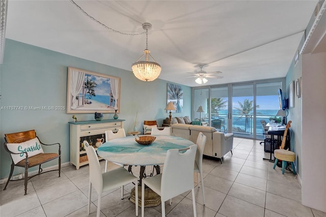 dining area with a wall of windows, ceiling fan with notable chandelier, baseboards, and light tile patterned floors